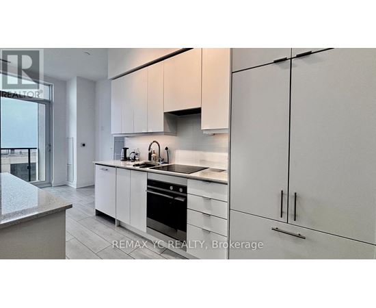 A modern kitchen with white cabinets and stainless steel appliances.