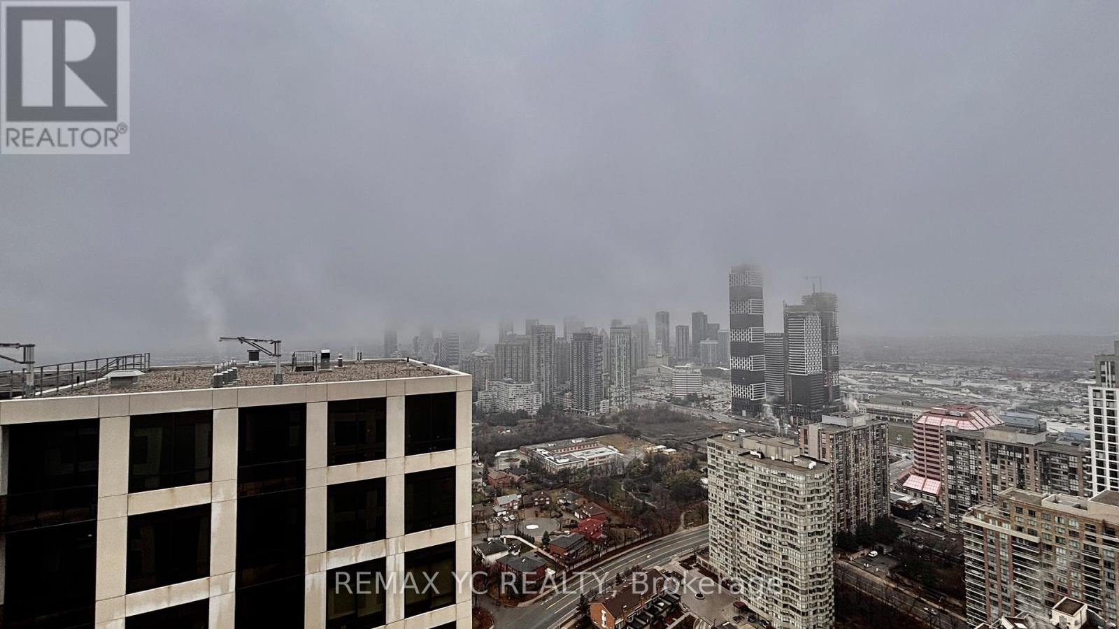 A cityscape with buildings and a hazy sky.