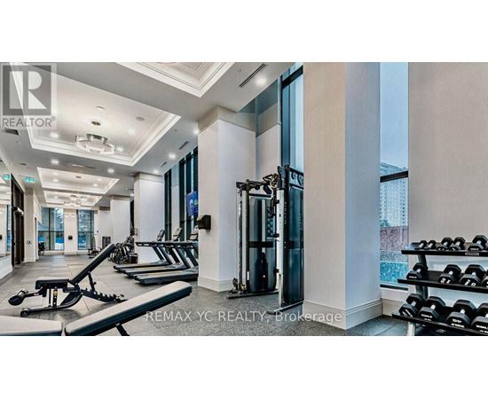 A well-lit gym with a variety of equipment including treadmills, weights, and exercise machines.