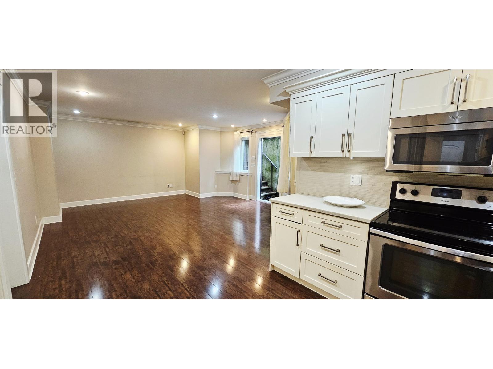 A kitchen with white cabinets and a black stove top oven.