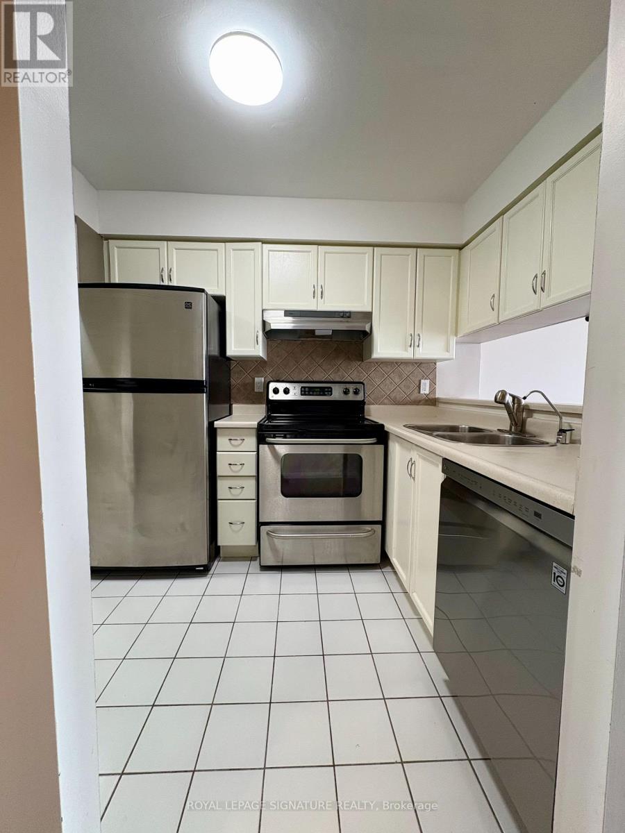 A kitchen with white cabinets and a stainless steel refrigerator.