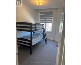 A bedroom with a bunk bed and a window with blinds.