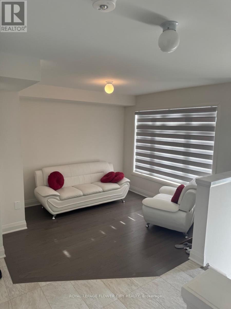 A living room with a white couch and a white chair.