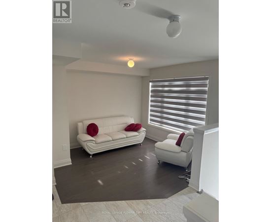A living room with a white couch and a white chair.