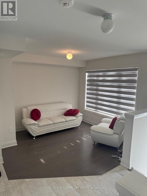 A living room with a white couch and a white chair.