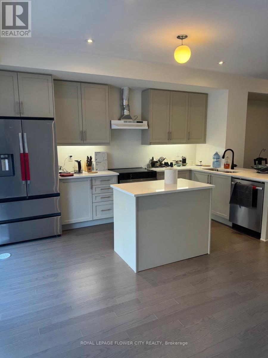 A modern kitchen with a white island and wooden floors.