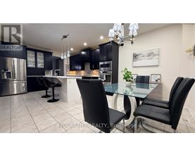 A modern kitchen with a glass table and black chairs.