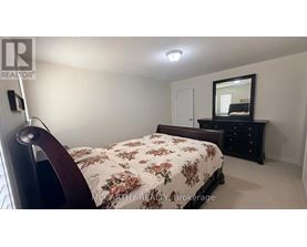 A bedroom with a floral bedspread and a mirror on a dresser.