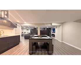 A spacious room with a wooden table and a TV mounted on the wall.