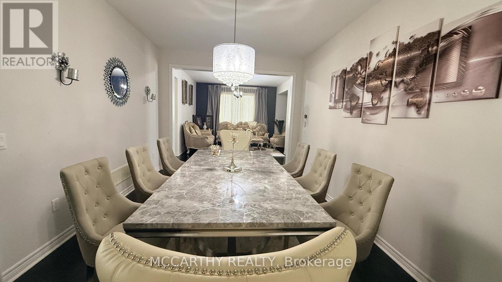 A dining room with a large table and chairs.