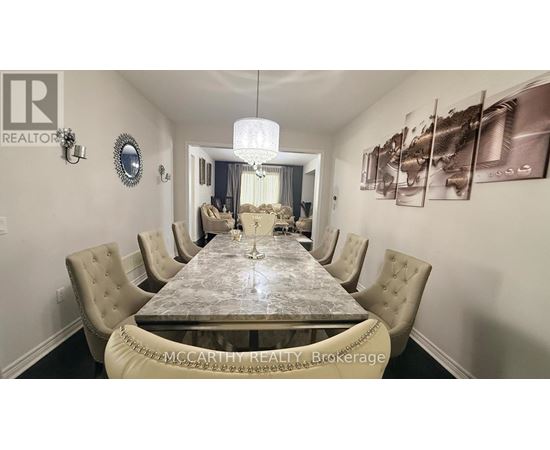 A dining room with a large table and chairs.