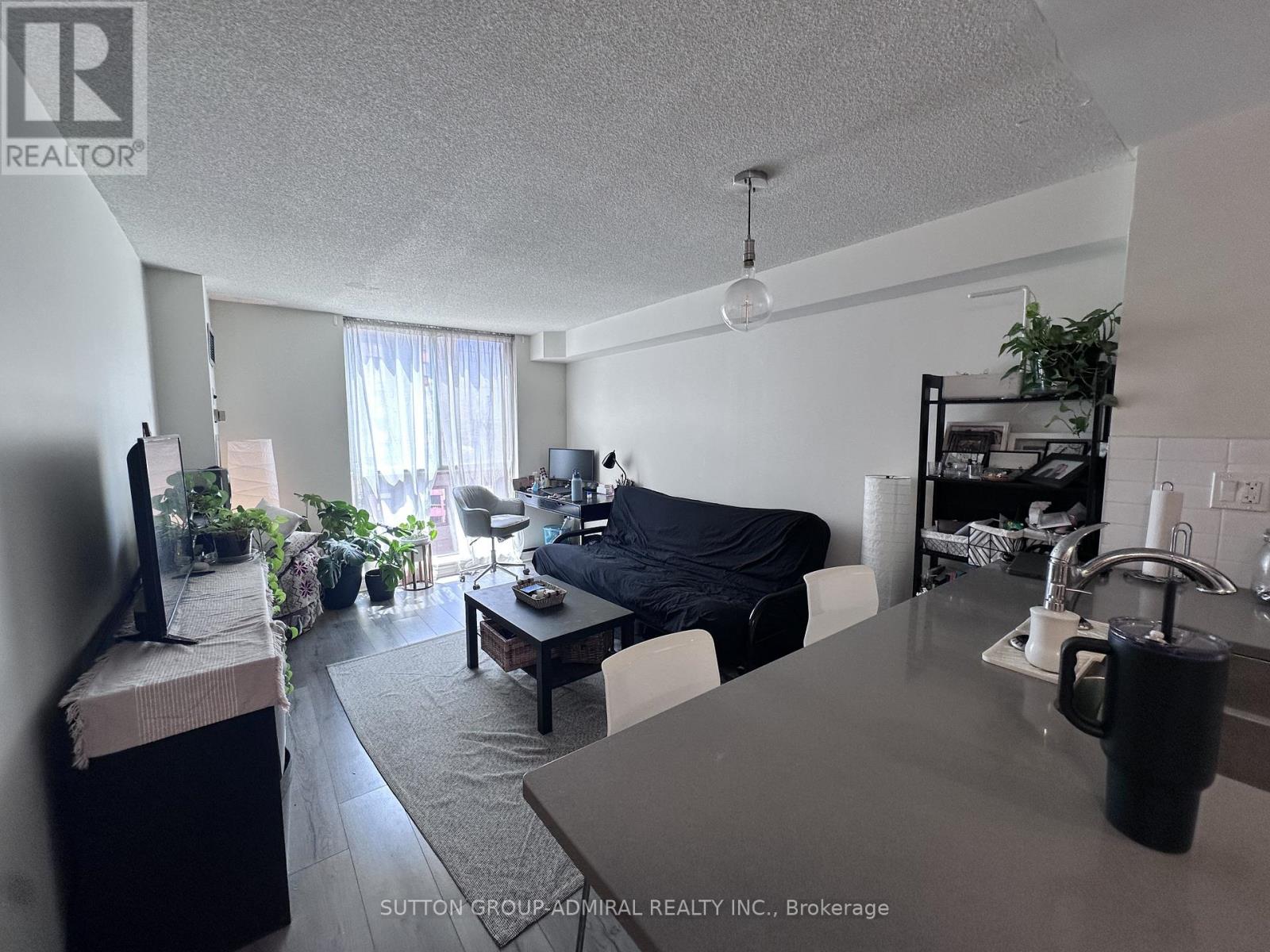 A kitchen with a sink and a window overlooking a building.