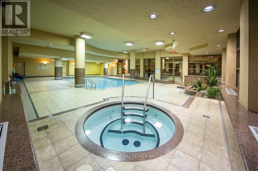A large indoor swimming pool with a hot tub in the middle.