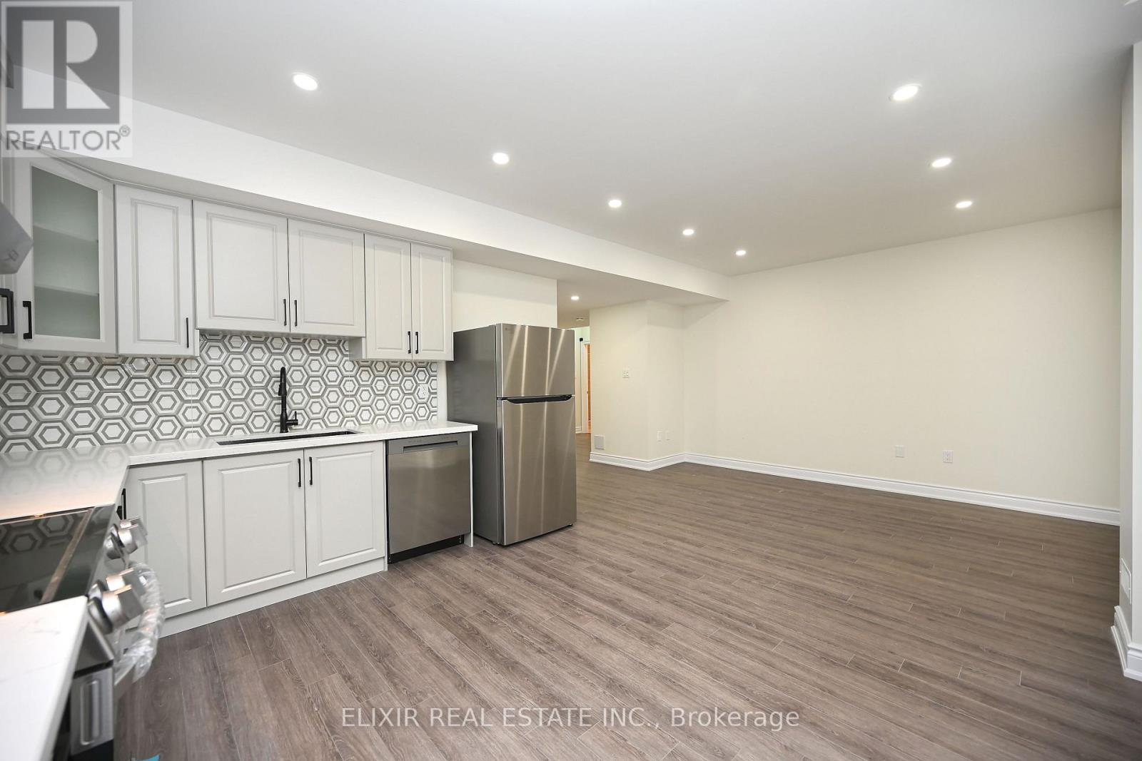 A kitchen with white cabinets and a tile backsplash.