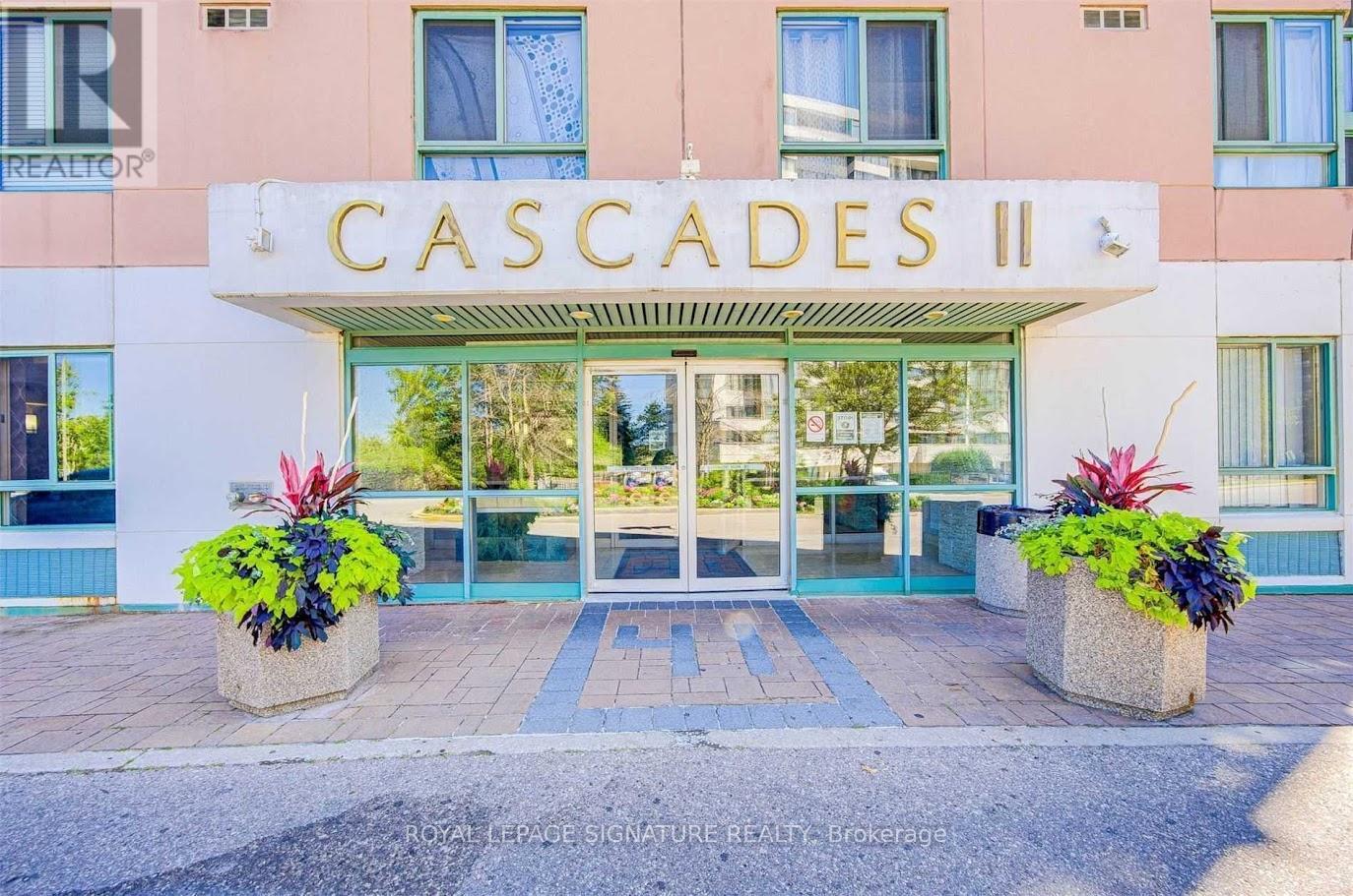 The front of a building named Cascades II with a glass door entrance.