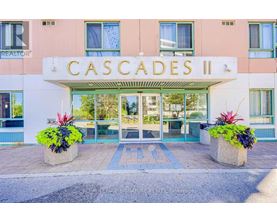 The front of a building named Cascades II with a glass door entrance.