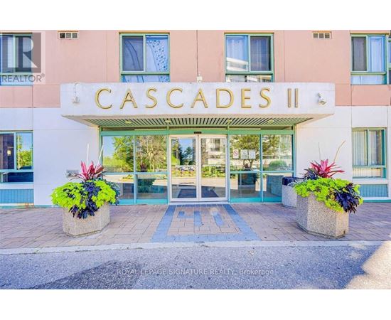 The front of a building named Cascades II with a glass door entrance.