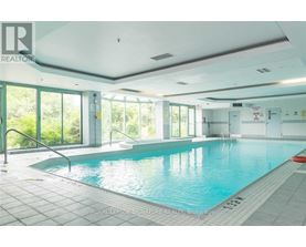 A large indoor swimming pool with a glass wall on one side.
