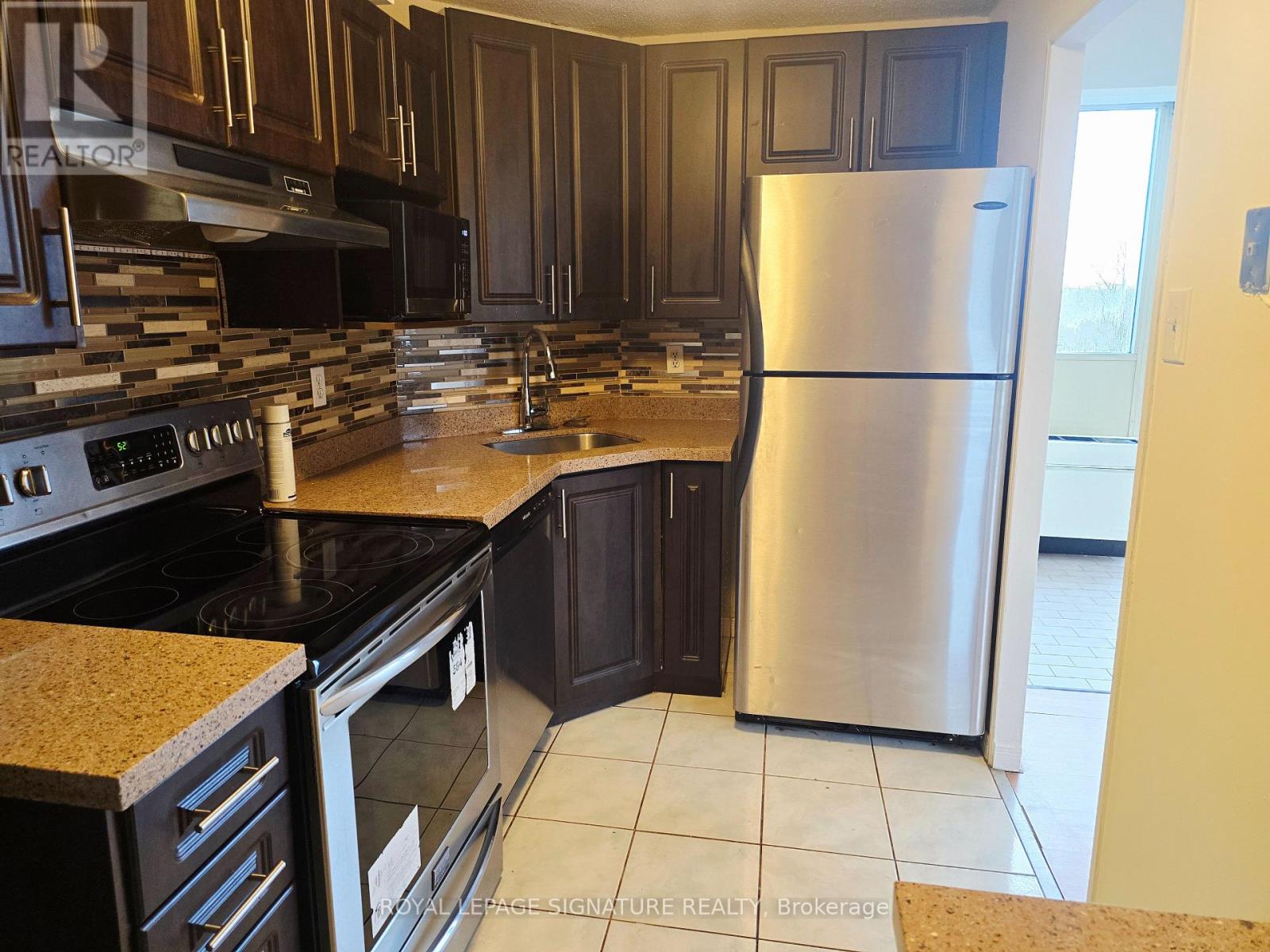 A kitchen with a stove top oven and a refrigerator.