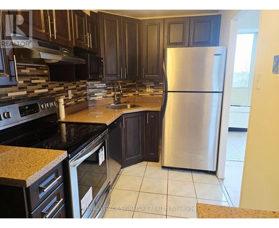 A kitchen with a stove top oven and a refrigerator.