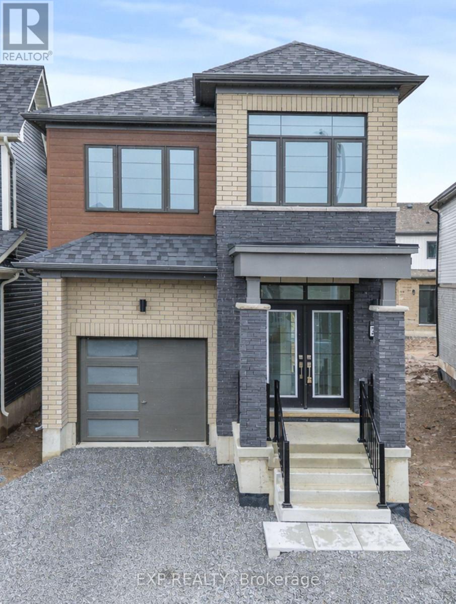 A modern house with a grey garage door and a black metal railing.