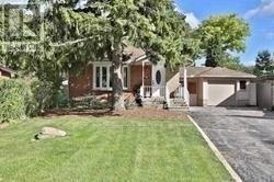 A house with a driveway and a lawn in front.
