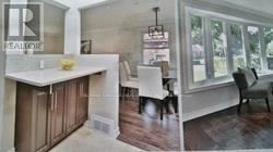A white kitchen with a wooden island and a black chair.