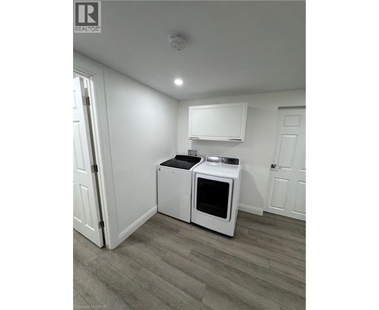 A white microwave oven and a white toaster oven are on a counter in a kitchen.