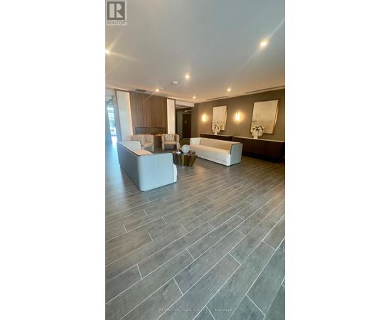 A spacious living room with a grey floor and a white sofa.