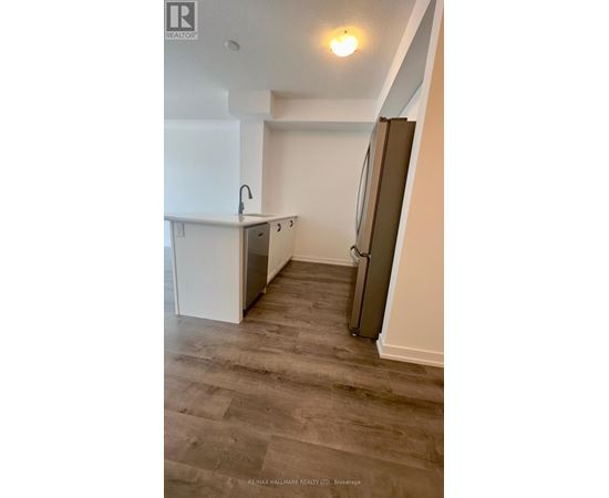 A kitchen with a sink and a refrigerator.