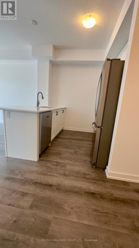 A kitchen with a sink and a refrigerator.