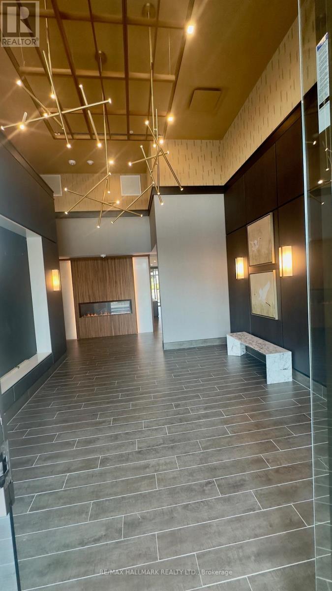 A hallway with a tiled floor and a glass wall on the right side.