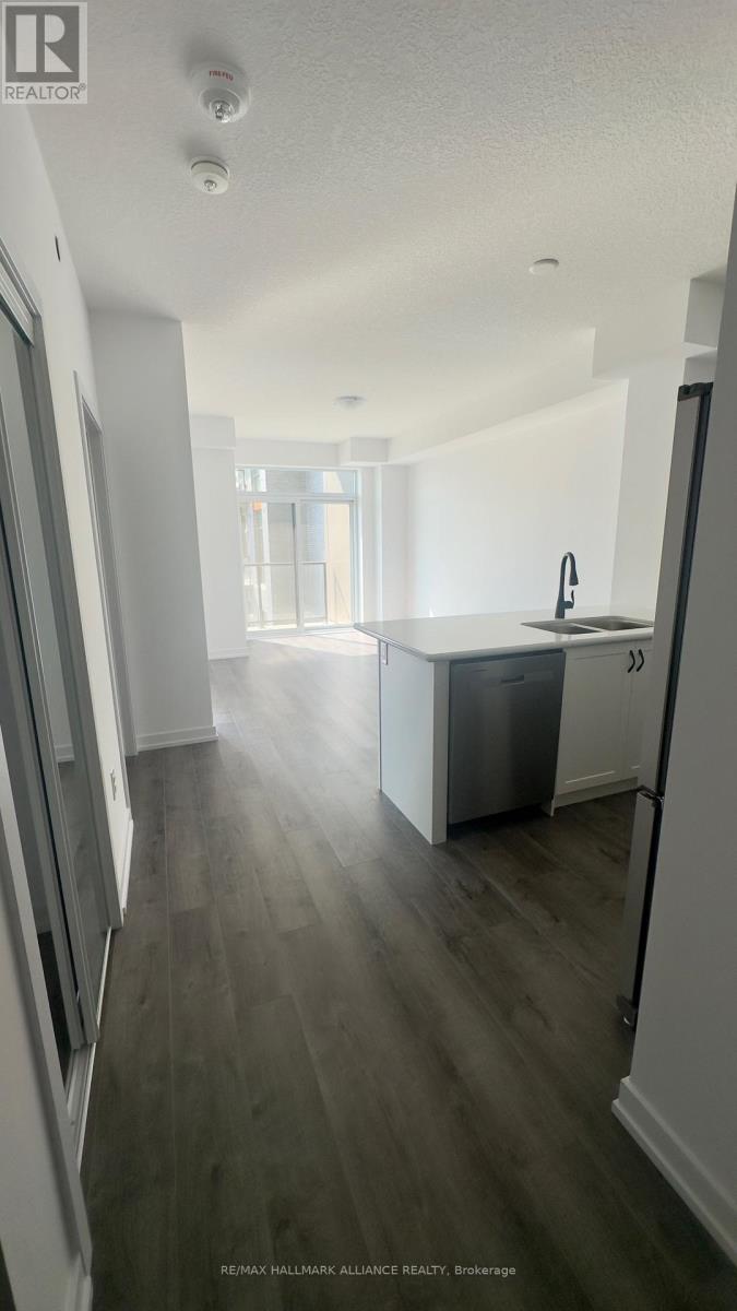 A kitchen with a refrigerator, sink, and cabinets.