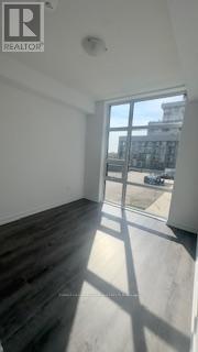 A room with a large window and wooden flooring.