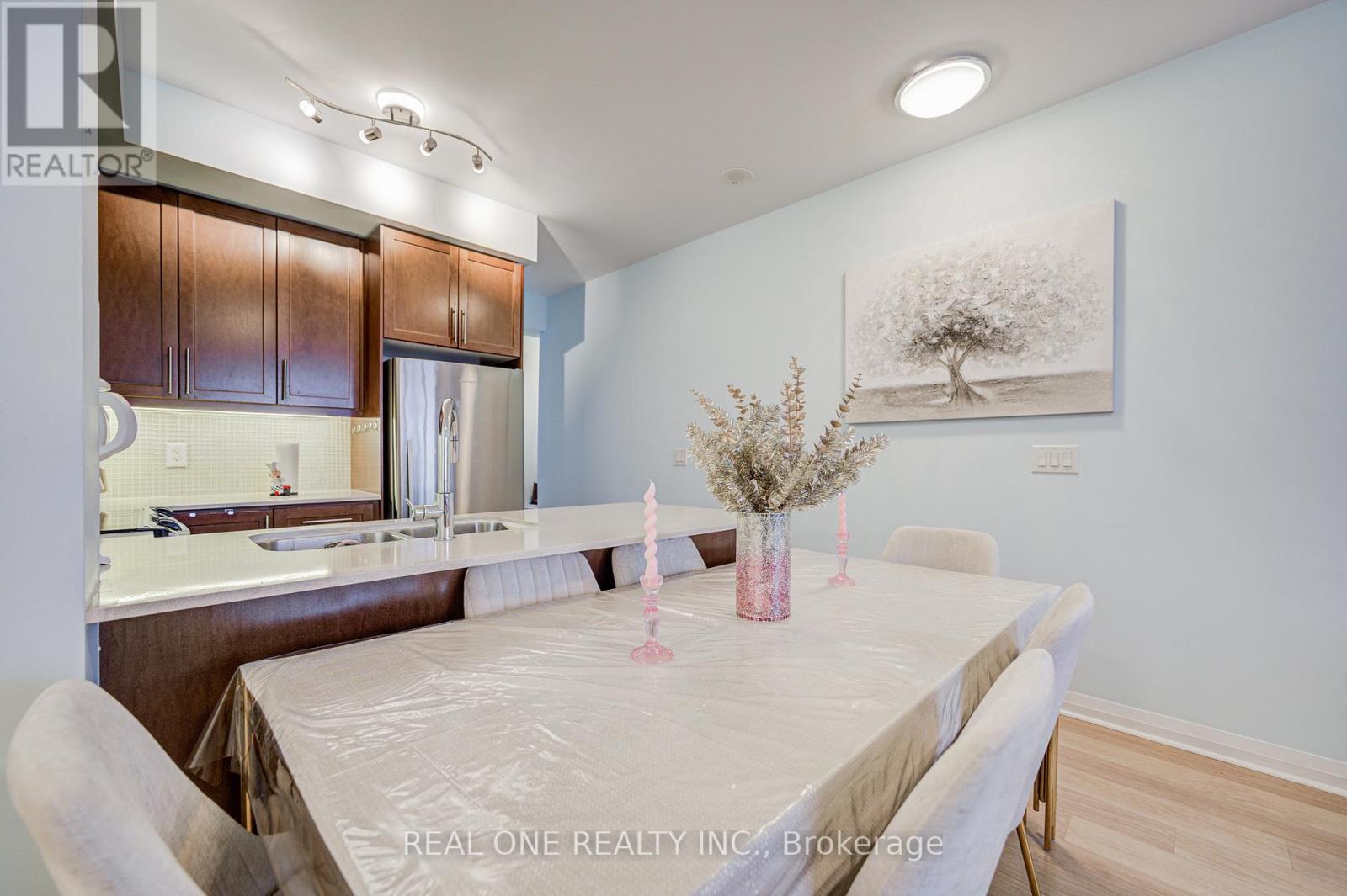A dining room with a table set for two and a painting on the wall.