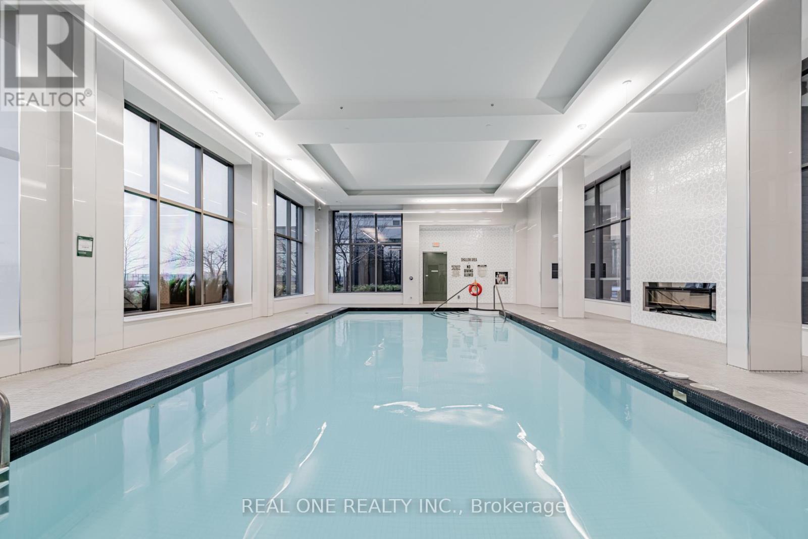 A large indoor swimming pool in a spacious room.