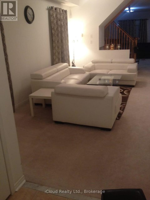 A living room with a white couch and a glass coffee table.
