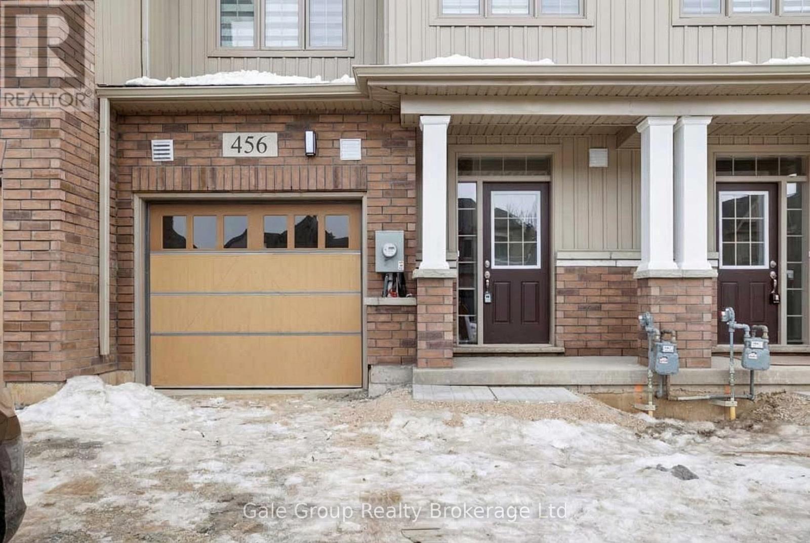A house with a brown garage door and a sign that says "REALTOR" on the wall.