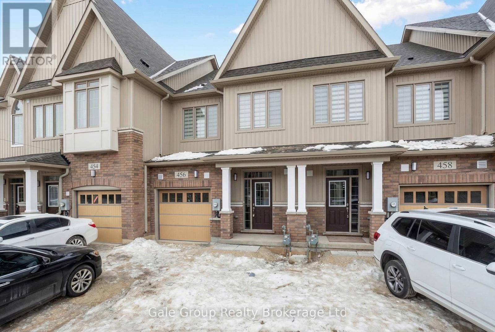A row of houses with cars parked in front.