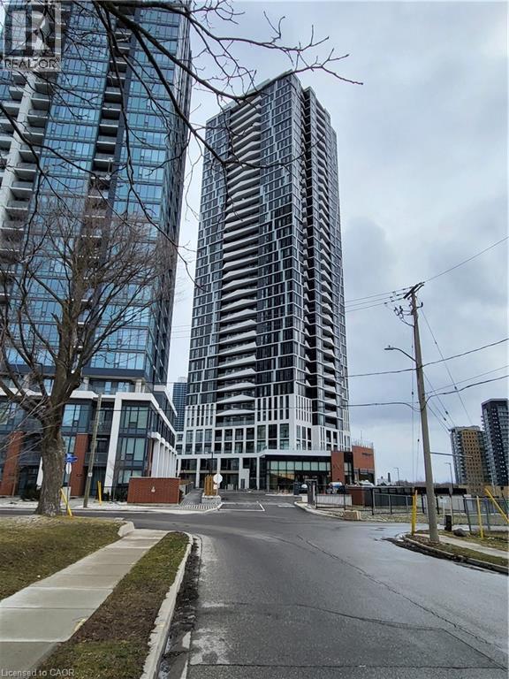 A tall building with many windows stands in front of a shorter building with a sign that reads "REALTOR".