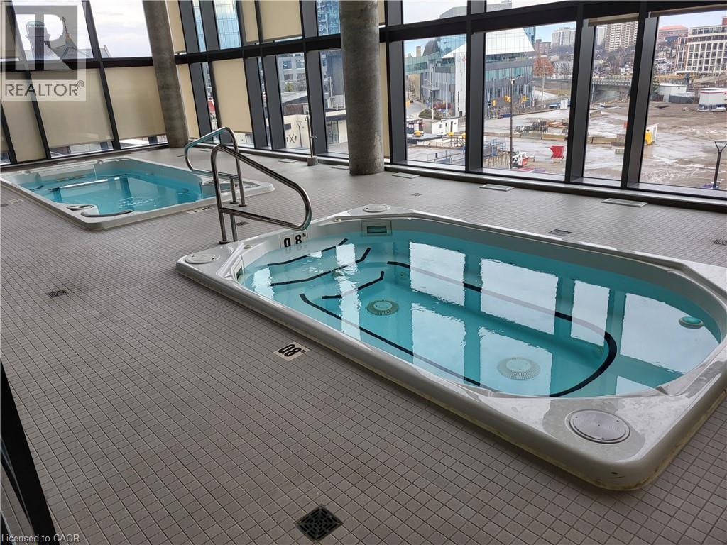 A large indoor swimming pool with a view of the city outside the windows.