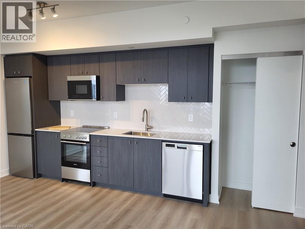 A modern kitchen with dark wood cabinets and stainless steel appliances.