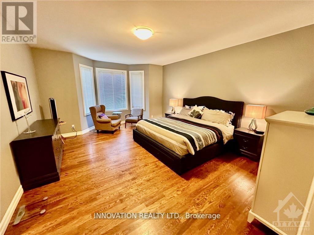 A bedroom with a large bed and a wooden floor.
