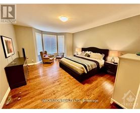 A bedroom with a large bed and a wooden floor.