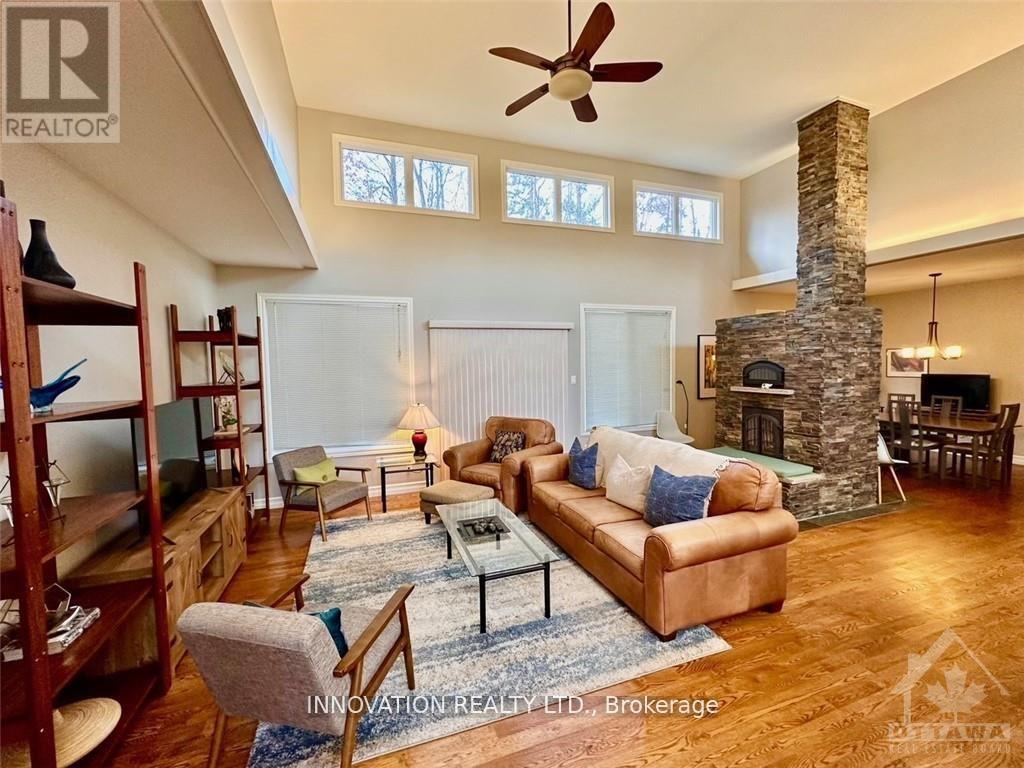 A living room with a stone fireplace and a brown couch.