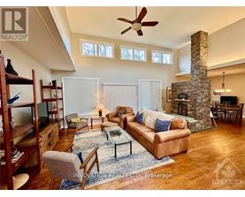 A living room with a stone fireplace and a brown couch.