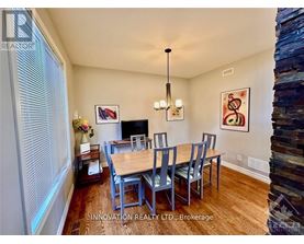 A dining room with a wooden table and chairs.