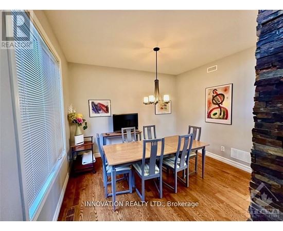 A dining room with a wooden table and chairs.