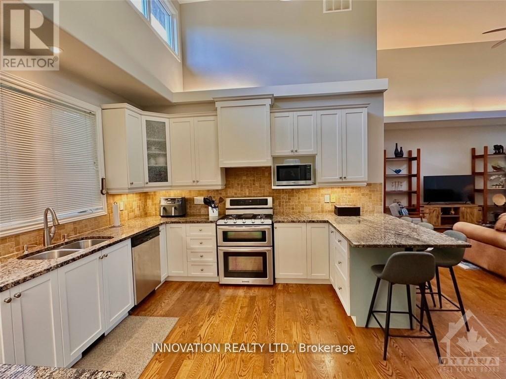 A kitchen with white cabinets and a wooden floor.