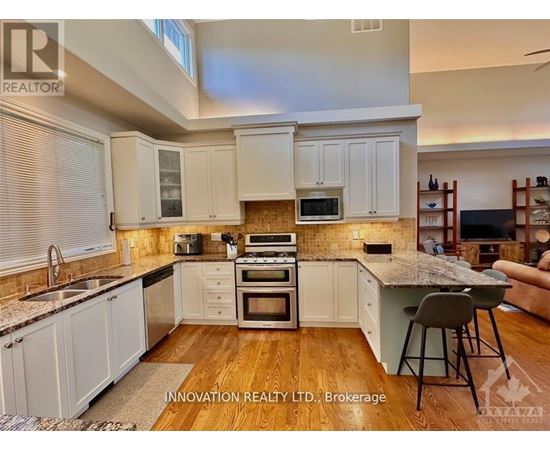 A kitchen with white cabinets and a wooden floor.
